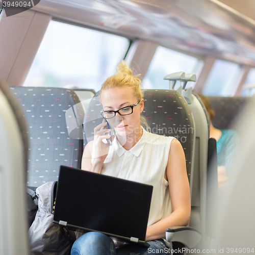 Image of Business woman working while travelling by train.