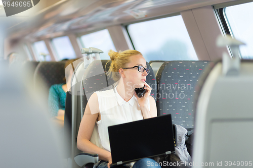 Image of Business woman working while travelling by train.