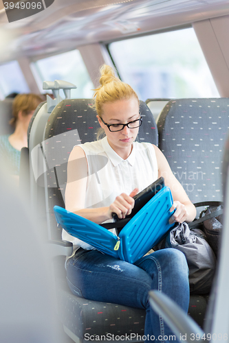 Image of Woman travelling by train working on laptop.