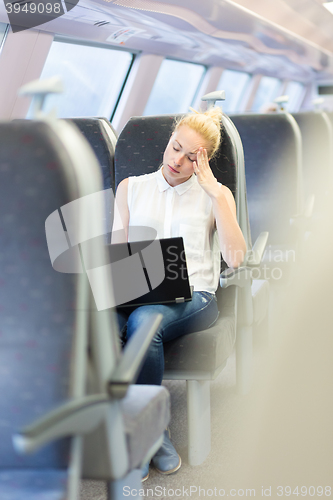 Image of Woman sleeping while travelling by train.