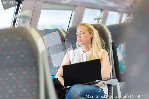 Image of Woman sleeping while travelling by train.