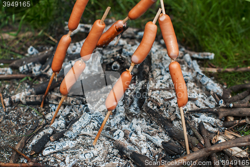 Image of grilled sausages on camp fire