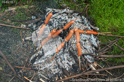 Image of grilled sausages on camp fire