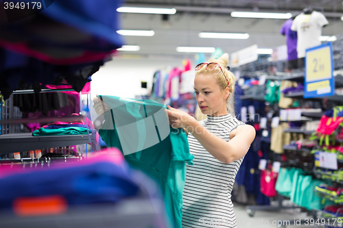 Image of Woman shopping sportswear in sports store.