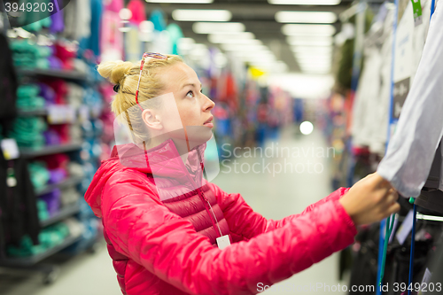 Image of Woman shopping sportswear in sports store.