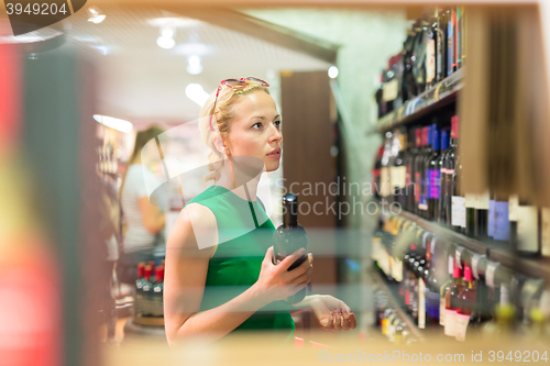 Image of Woman shopping groceries at supermarket.