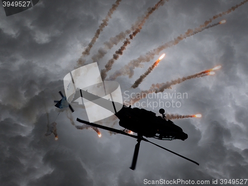 Image of Silhouette of an attack helicopter firing flares