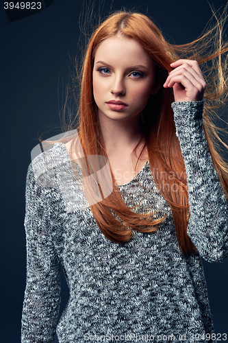 Image of Beautiful red haired female in grey sweater