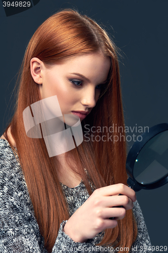 Image of Woman looking through magnifying glass