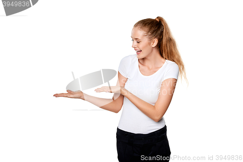 Image of Smiling woman showing open hand palm with copy space