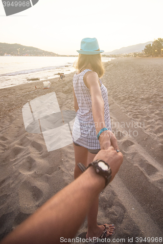 Image of Girl holding a hand man on the beach