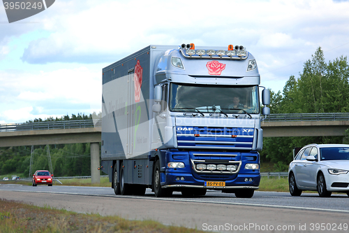 Image of DAF XF Flower Truck Moves along motorway among traffic