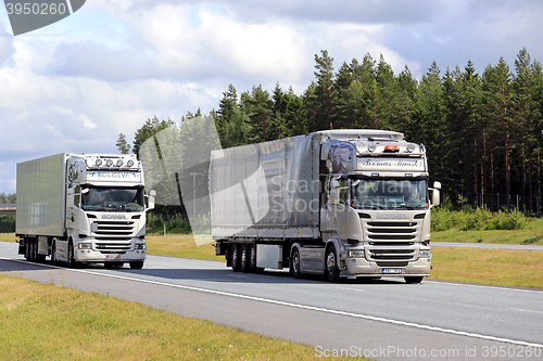 Image of Scania R490 Cargo Truck Overtakes another Truck on Motorway