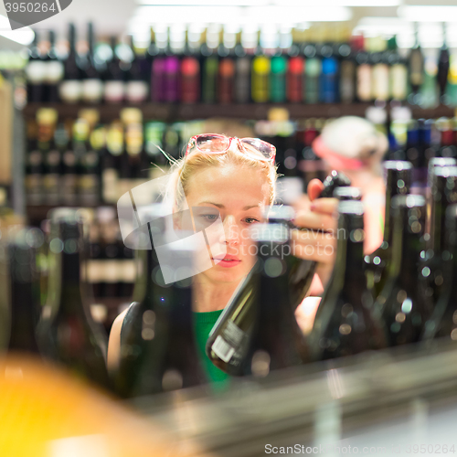 Image of Woman shopping groceries at supermarket.