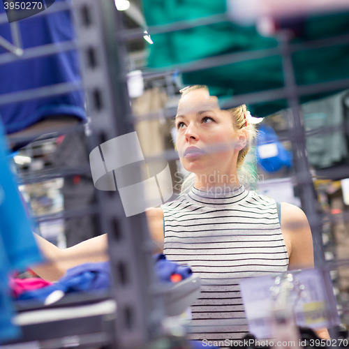 Image of Woman shopping sportswear in sports store.