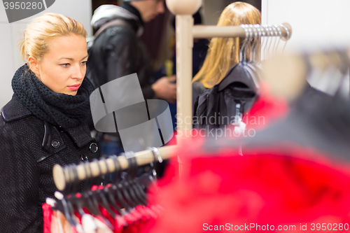 Image of Beautiful woman shopping in clothing store.