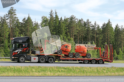 Image of Scania Truck Hauls Aerial Work Platforms along Freeway 