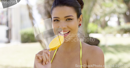 Image of Happy woman eating icicle dessert