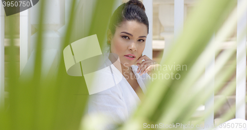 Image of Attractive young woman framed by palm leaves