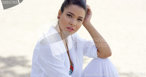 Image of Charming woman sitting with head resting on hand