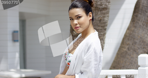 Image of Beautiful woman leaning on fence outside