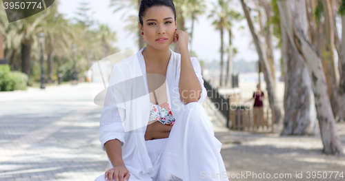 Image of Calm woman in white robe sitting outdoors