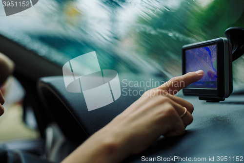 Image of woman looks at a GPS Navigator in the car