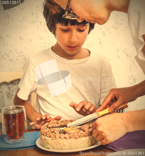 Image of mom with son cut a birthday cake