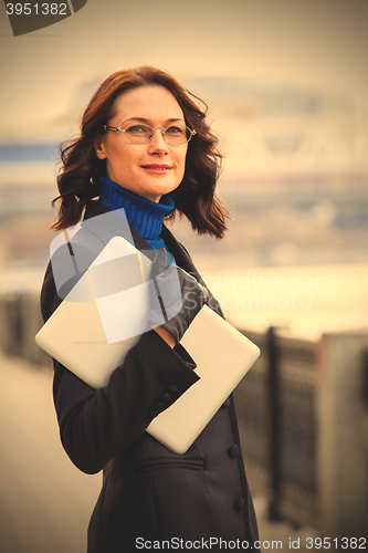 Image of woman with glasses and laptop outdoors