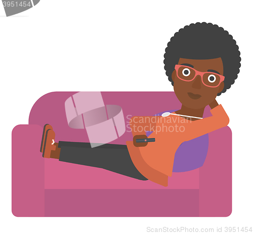 Image of Woman sitting on the couch with remote control.