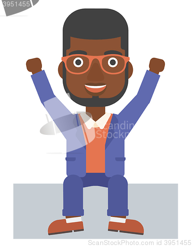 Image of Man sitting with raised hands up.