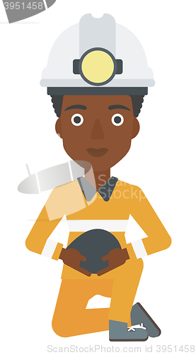 Image of Miner holding coal in hands.
