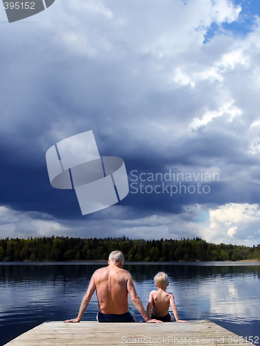 Image of Grandfather and Grandson sitting on a footbridge