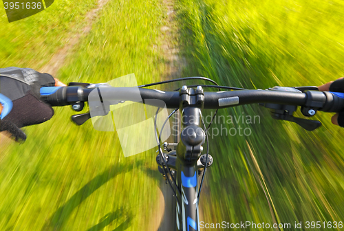 Image of Fast motion mountain bike on a grassy road