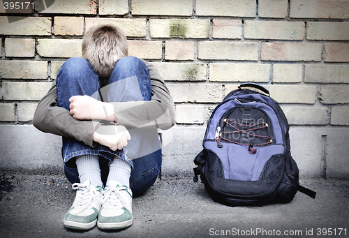 Image of upset boy against a wall