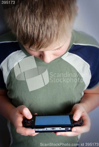 Image of Boys hand playing portable video game