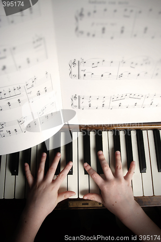 Image of child's hands playing on a old piano