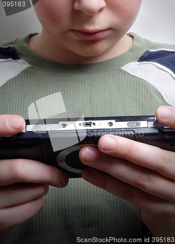 Image of Boys hand playing portable video game