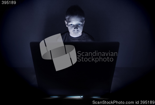 Image of Boy illuminated by the blue light of a computer monitor