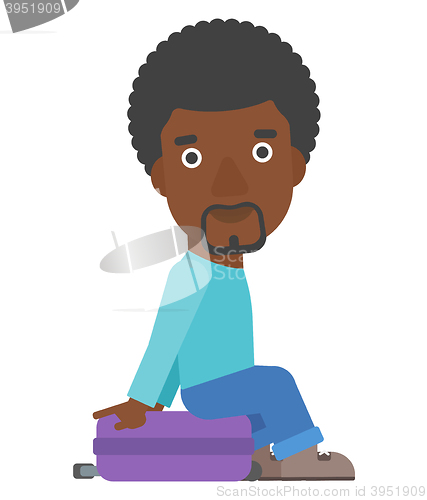 Image of Man sitting on his suitcase.