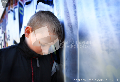 Image of upset boy against a wall