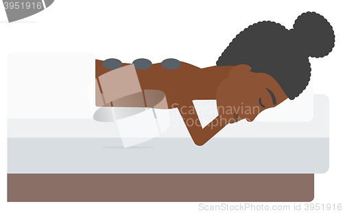 Image of Woman getting stone therapy.