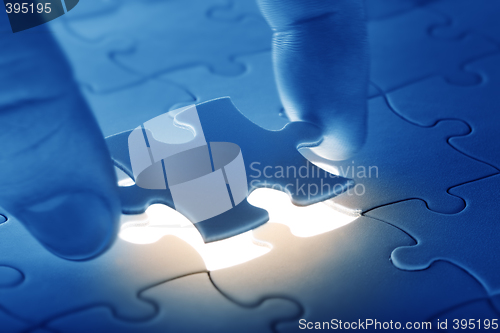 Image of Hands placing last piece of a Puzzle