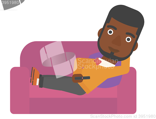 Image of Man sitting on the couch with remote control.