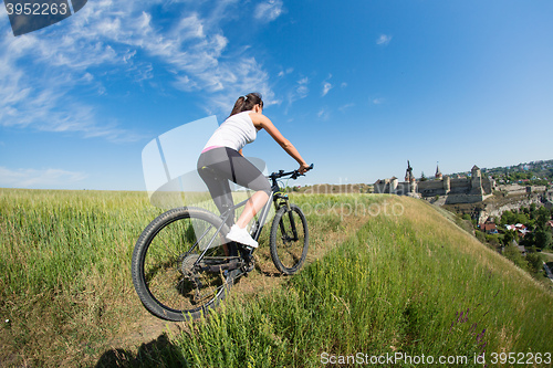 Image of Sport bike woman on the meadow with a beautiful landscape