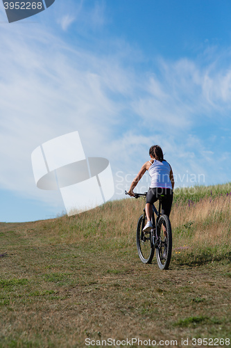 Image of Sport bike woman on the meadow with a beautiful landscape