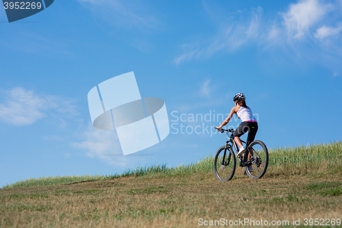 Image of Sport bike woman on the meadow with a beautiful landscape