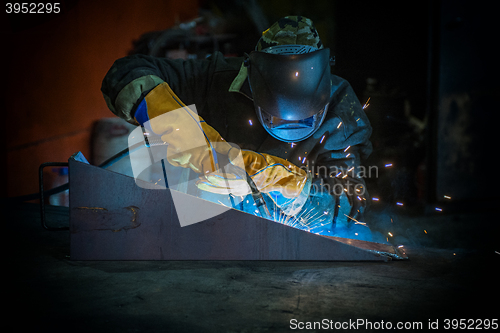 Image of worker welding metal