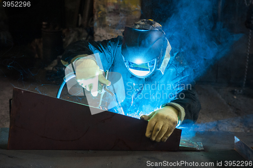 Image of worker welding metal