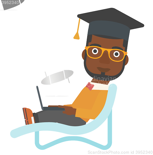 Image of Graduate lying on chaise lounge with laptop.